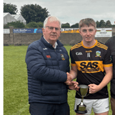 St Patrick's captain Finn Madigan receives the cup from South Tipperary GAA Chairman and fellow St Patrick's clubman Nicholas Moroney. Also included is Seamus Walsh, Vice-Chairman of South Tipp GAA