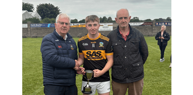 St Patrick's captain Finn Madigan receives the cup from South Tipperary GAA Chairman and fellow St Patrick's clubman Nicholas Moroney. Also included is Seamus Walsh, Vice-Chairman of South Tipp GAA