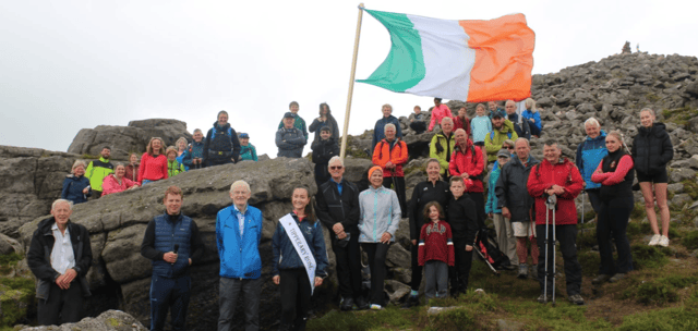 Hikers gathered around the Irish flag at the summit of Slievenamon at last year's Slievenamon Day commemoration