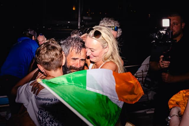 An emotional John O’Driscoll celebrates the achievement with his wife Aoife and 10-year-old son Riain at the finish line
