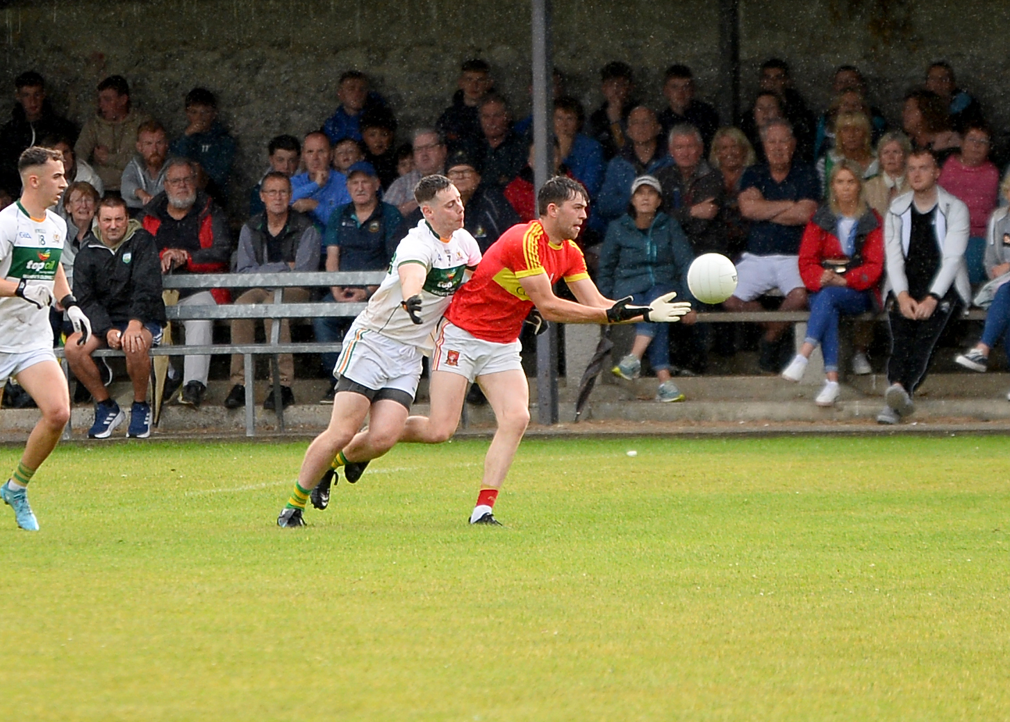Killenaule's Jack Hassett gets a pass away despite the challenge of Clonmel Commercials' Ciaran Cannon. Picture: Michael Boland