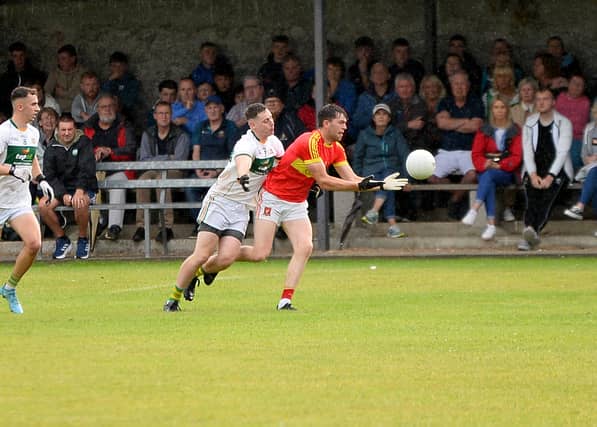 Killenaule's Jack Hassett gets a pass away despite the challenge of Clonmel Commercials' Ciaran Cannon. Picture: Michael Boland