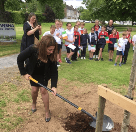 Ambassador of Palestine, planting a tree on the village green in Bansha, as part of her visit to the area