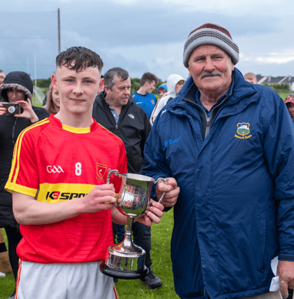 Killenaule captain Shane Ryan accepts the cup from County Bord na nÓg chairman, Tommy Landers, after Killenaule defeated Silvermines in the Under 15B county football final played at Leahy Park.