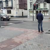 A pedestrian waits to cross Liberty Square