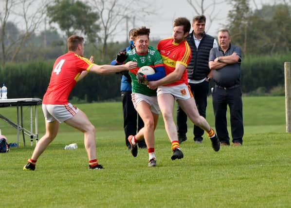 Loughmore's Conor Ryan tries to break through the challenges of Jimmy Feehan and Cillian O'Dwyer.