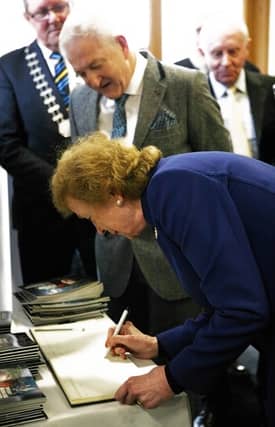 Mary Robinson signing the visitors book