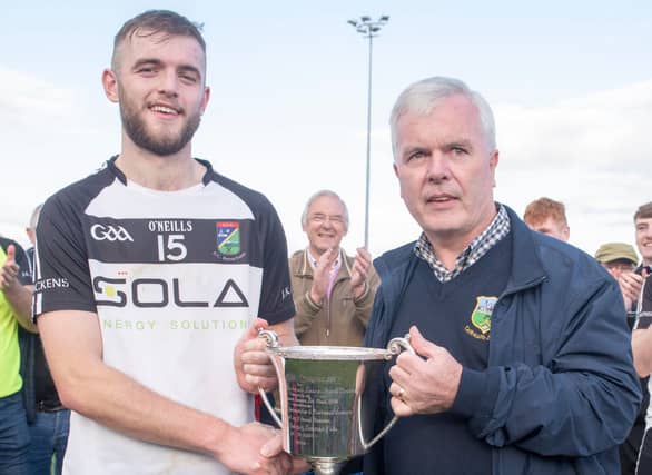 JK Bracken's captain Michael Egan pictured accepting the cup from County Football Board Committee Chairman Barry O'Brien following their win over Cahir in the county minor A football final.