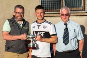 Sponsor John McCarra presents the cup to Carrick Swan captain Ryan Waters. Also included is Nicholas Moroney, South Tipperary GAA Chairman​