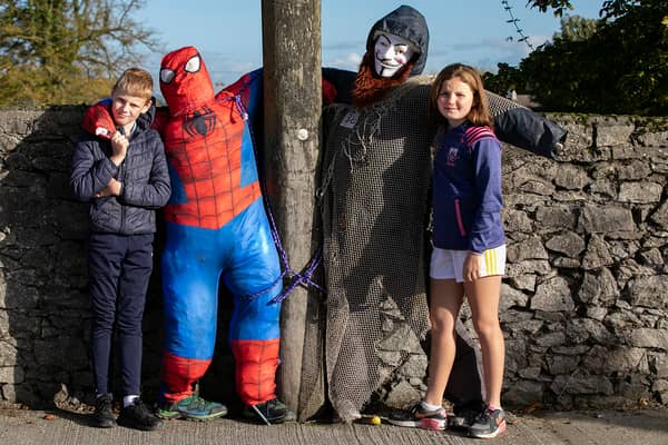 Evan Moloney and Saoirse Harnett pose for a photo with two of the scarecrows displayed in New Inn village for Spookfest a few years ago.
