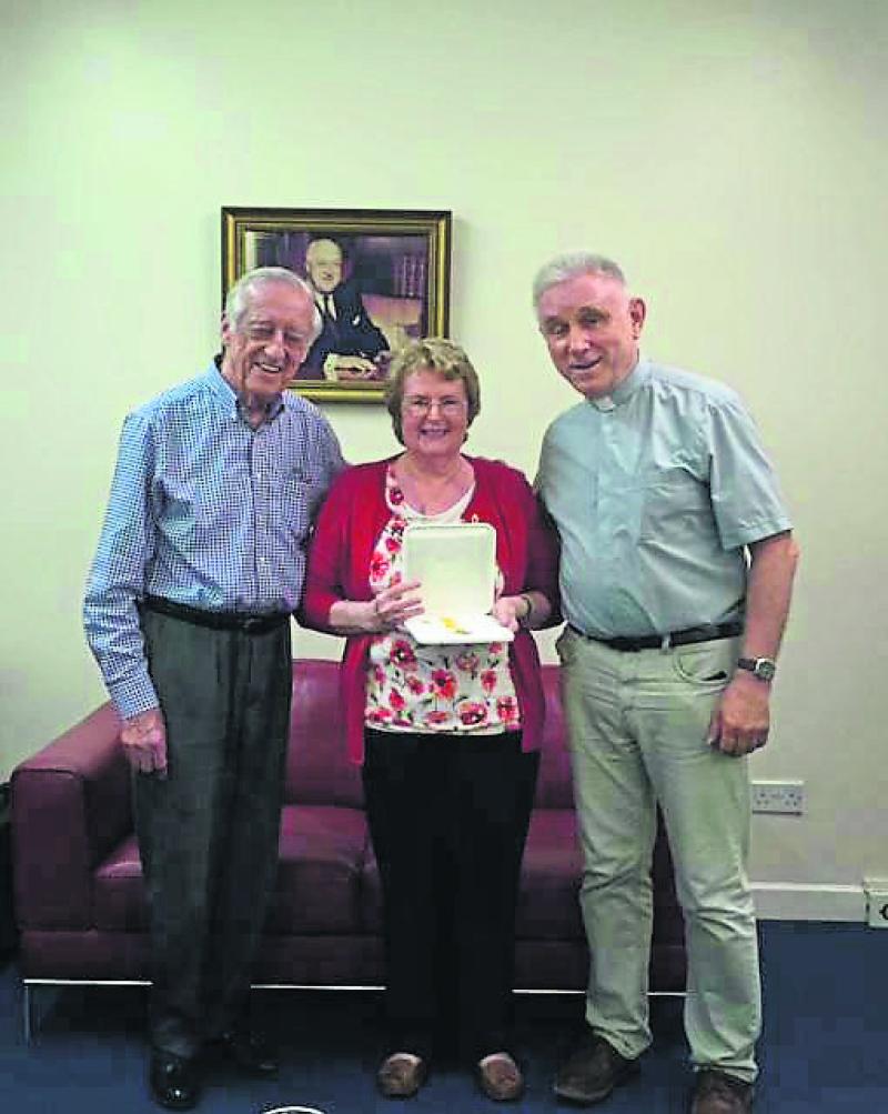 The photo shows John Cox – Chair of the Trustees and Fr Eamonn Mulcahy with Johanne O'Rourke Corbett at the presentation of her Benemerenti Medal.
