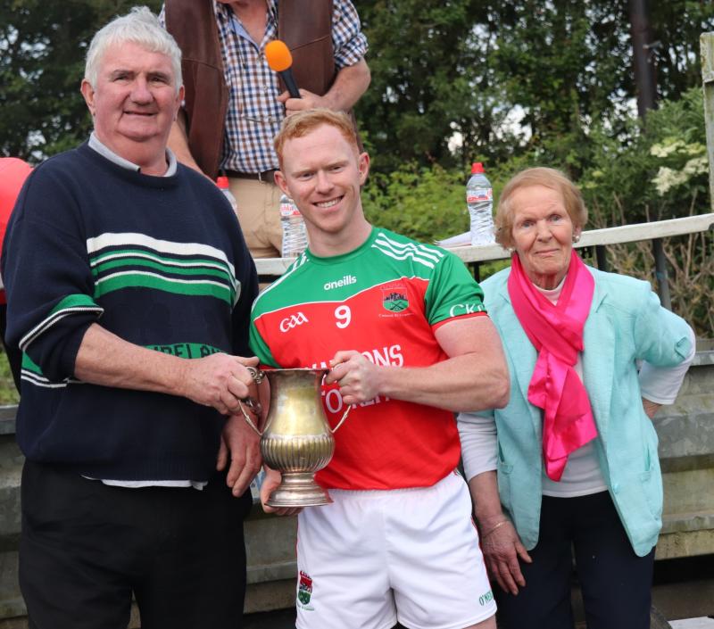 Adrian O’Dwyer of Cashel King Cormacs receives the Jamesie O’Donoghue Cup from West Board Chairman Michael Ryan C, in the presence of Jamesie’s mother Una O’Donoghue