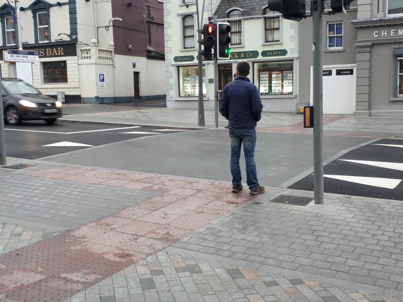 A pedestrian waits to cross Liberty Square