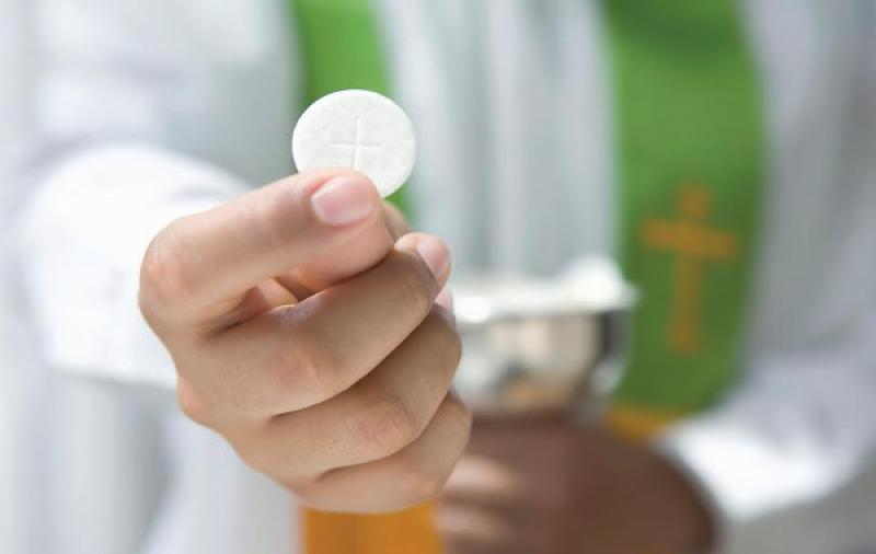 Priest Holding Communion Wafer --- Image by © Royalty-Free/Corbis