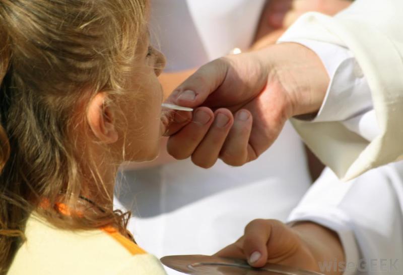 priest-giving-communion-to-a-young-girl