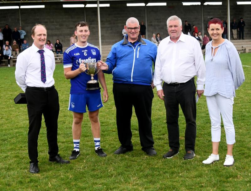 Thurles Sarsfields Captain Paddy Carroll is presented with the Thurles Credit Union Mid Tipp Junior B Cup by Brian King also present are Mid Chairman Joe O'Sullivan, Mid secretary Catherine Dunne and 