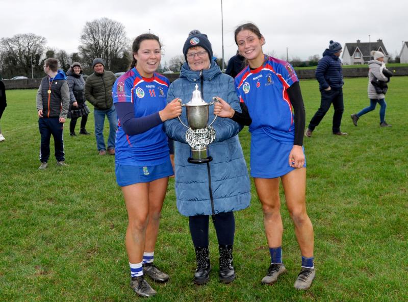 Secretary Munster Camogie Carmel Harkin presenting Ursuline Thurles captains Louise Hickey and Lorna Ryan with the cup in Boherlahan