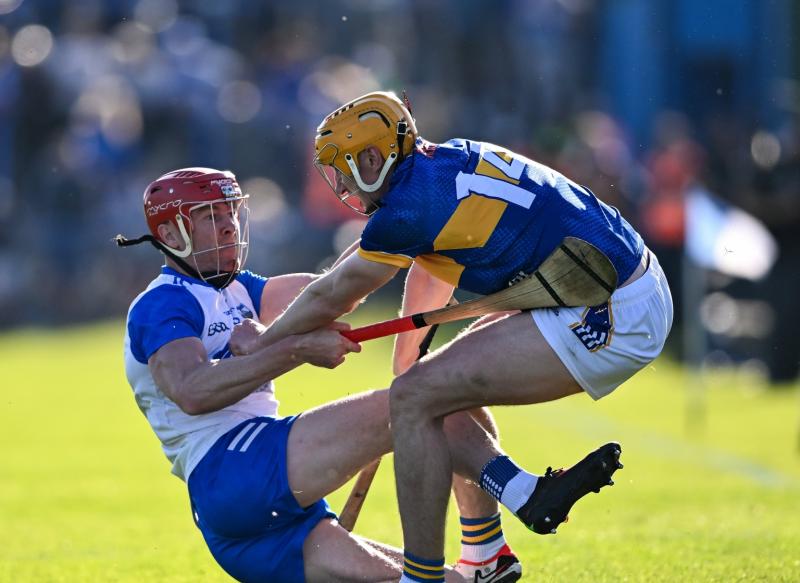 Mark Kehoe of Tipperary is tackled by Tadhg de Búrca of Waterford during the Munster GAA Hurling Senior Championship Round 3 match between Waterford and Tipperary .