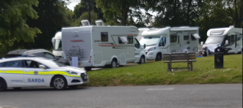 Photo shows the camper vans which have moved into the green field in Clara