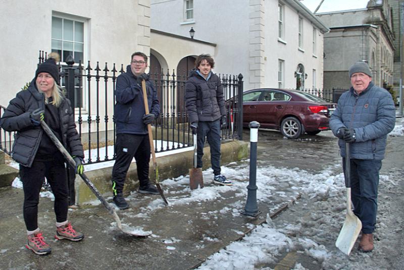 Hard at work shoveling snow and ice from footpaths in Carrick-on-Suir town centre 