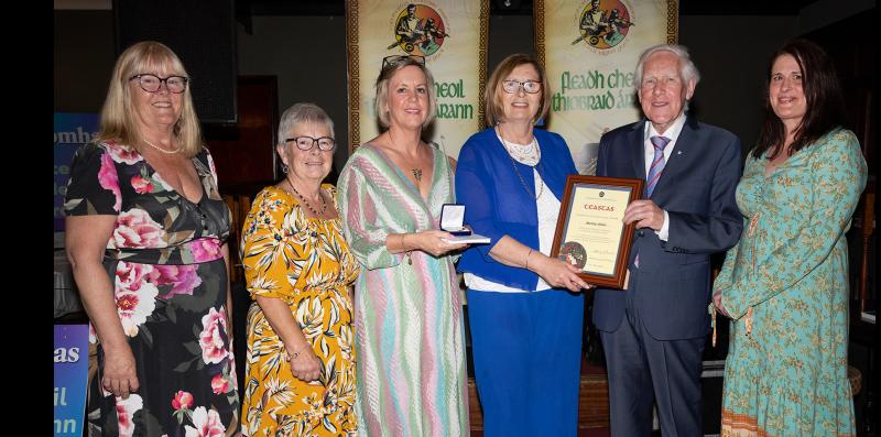 A long-time supporter of Comhaltas is presented with an award at Tipperary County Fleadh