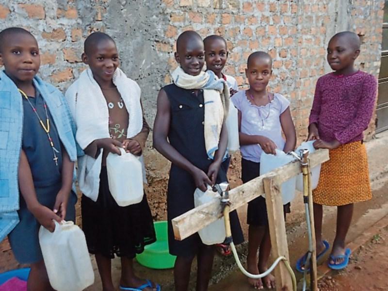Ugandan children enjoy fresh water from Roscrea