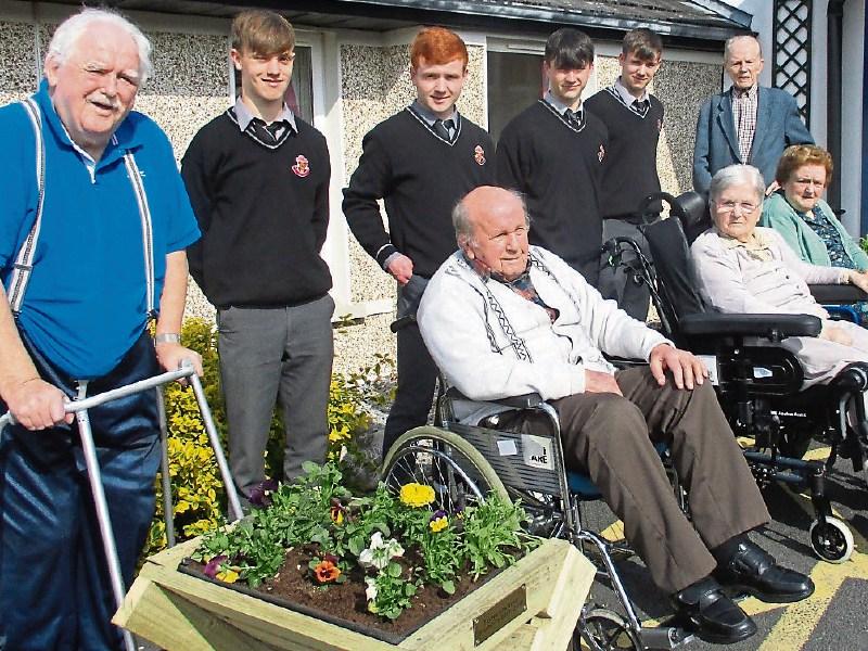 Carrick-on-Suir CBS Transition Year students presenting flower planters to residents of Greenhill Nursing Home.