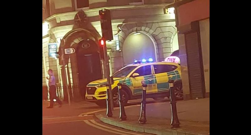Stricken pedestrian being attended to by emergency services on main street of big Tipperary town