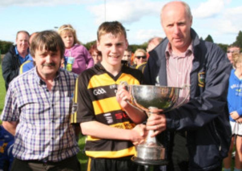 Darragh O'Dwyer, captain of the Arravale Rovers team that won the County u-14 'A' hurling title, receives the cup from County Bord na nOg chairman Joe Kennedy, with Bord PRO Neil Ryan.