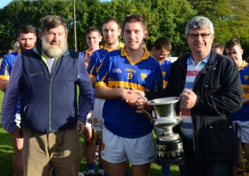 Kilsheelan/Kilcash captain Bill Maher accepts the Jerome ODwyer Cup from South Board chairman Michael Cooney after his sides South Intermediate hurling final success over St. Marys at Cahir on Saturday last. On the left is Noel Byrne, South Board treasurer.