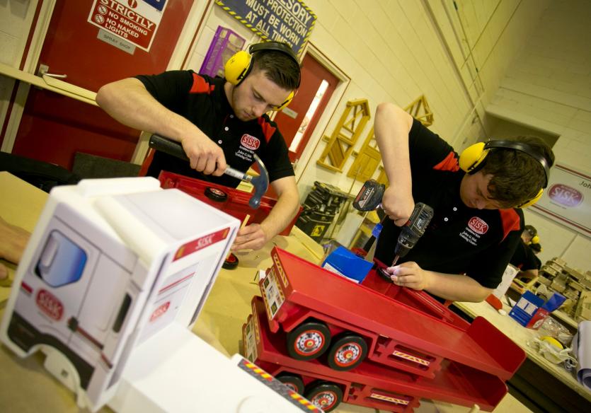 Apprentice carpenters putting the finishing touches to some handmade toys