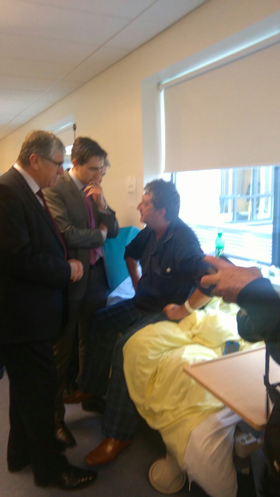 Minister Harris meets a patient on a hospital trolley